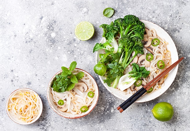 Vegetarian traditional Vietnamese soup Pho bo with herbs, rice noodles, broccolini, bok choy, bean sprouts, mushrooms. Vietnam national dish. Asian food concept.